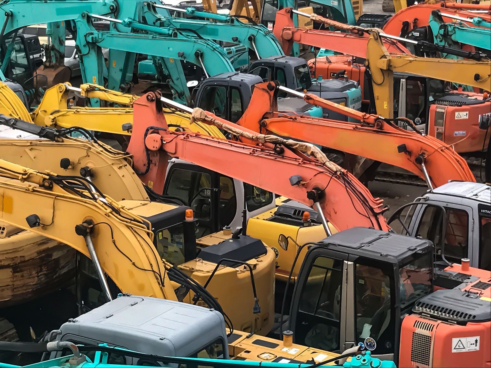 multiple used excavators in the storage area.